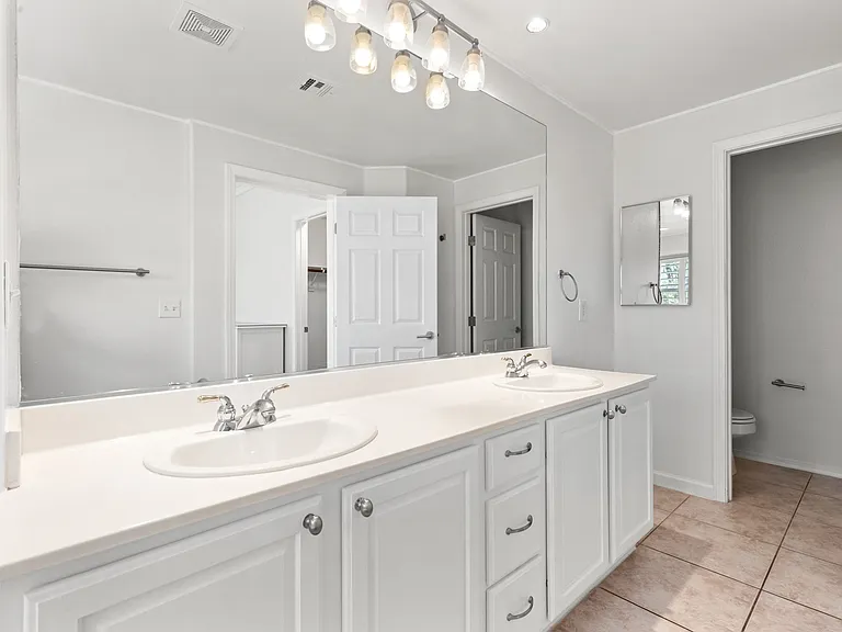 Dual sinks, WC, large shower/tub combo with upgraded glass door.