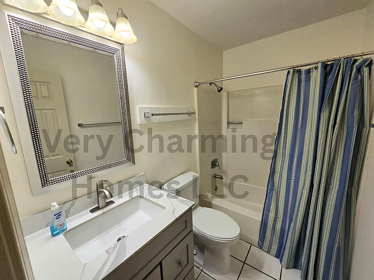 The bathroom has been freshly updated with a new vanity, mirror, and light.
