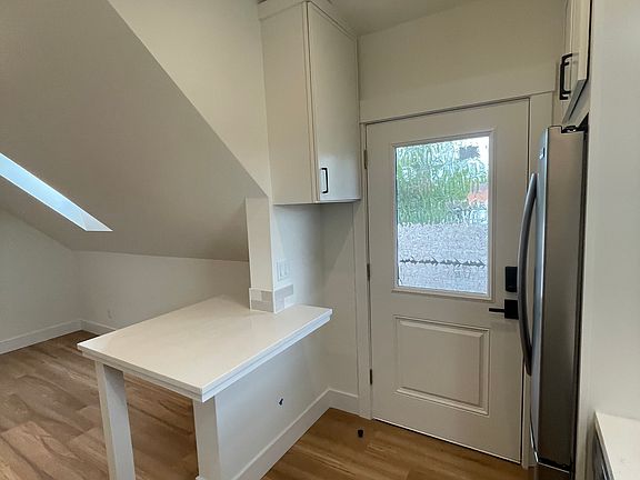 Private exterior entry into the kitchen with extra storage cabinet and built in island/table