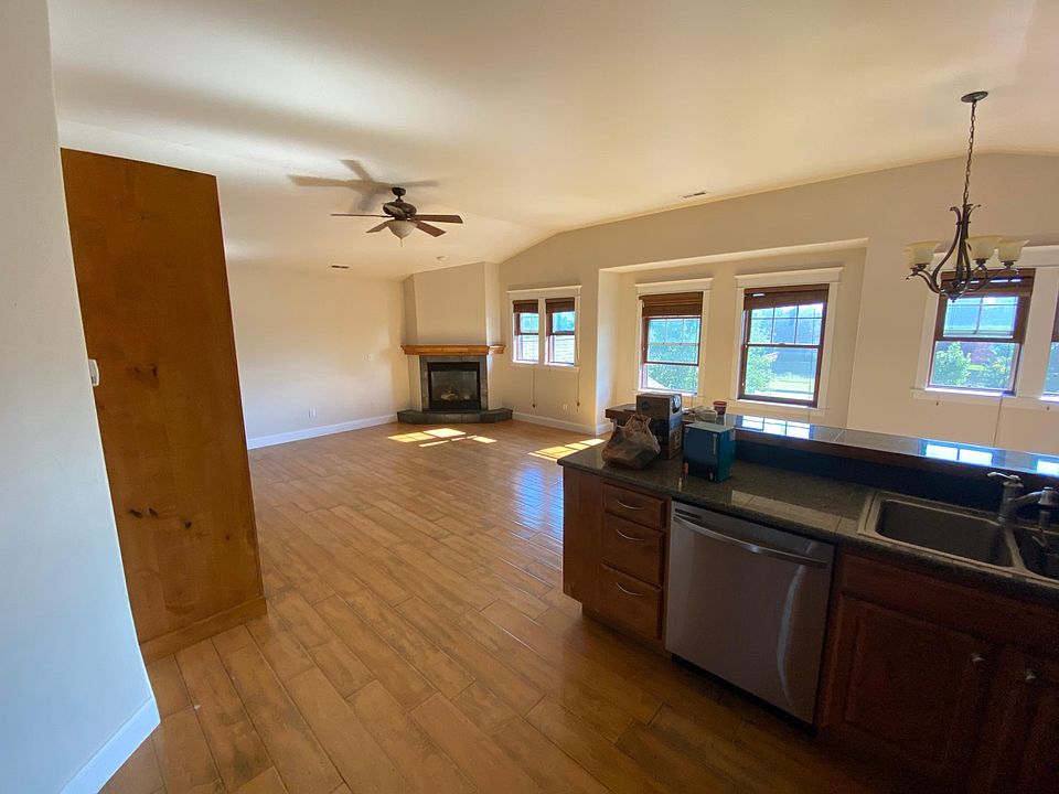Kitchen looking toward greatroom with fireplace and built- in floor to ceiling shelving