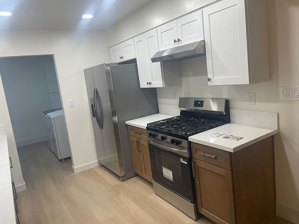Kitchen featuring quartz countertops, custom cabinetry, Delta fixtures, and recessed dimmable lighting