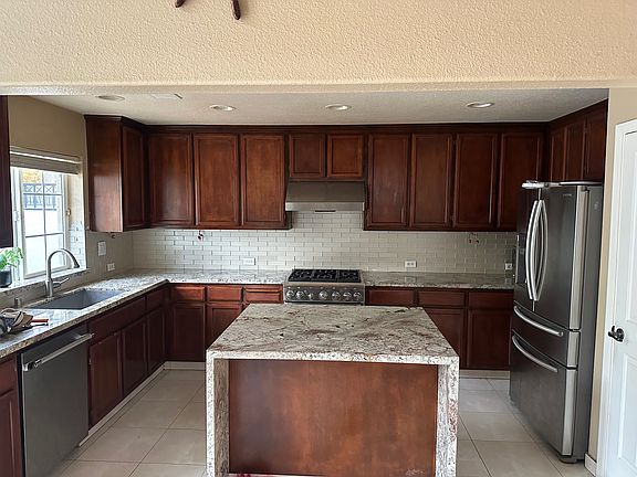 Kitchen with granite and waterfall island, thermodor appliances and new refridgerator