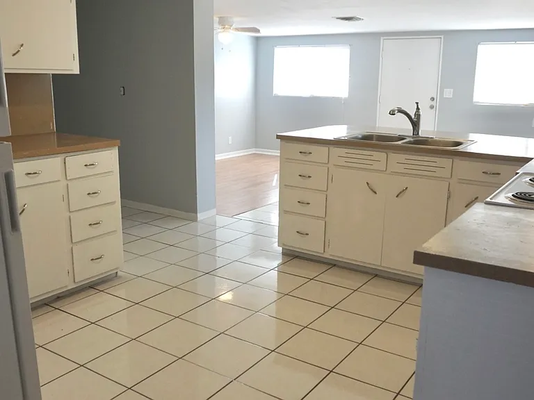 Kitchen with secondary living room in background