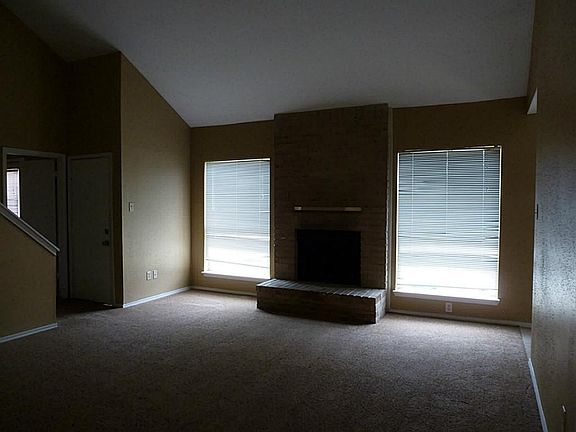 This is a great living room with wood burning fireplace, high ceilings, new carpet and new paint