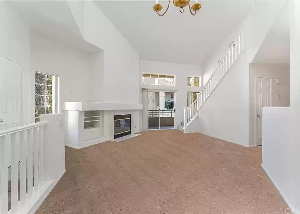 Living room, as seen from dining area. Patio door goes to main room balcony. Stairs go to 2nd story loft.