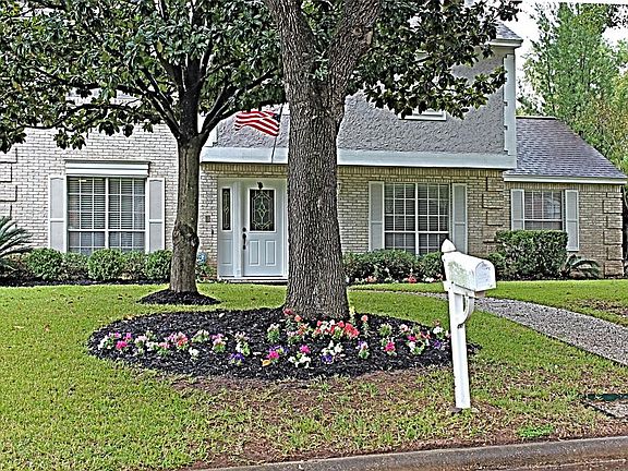 This close up of the home shows the pretty leaded glass front door with side panels and shutters. Pretty!