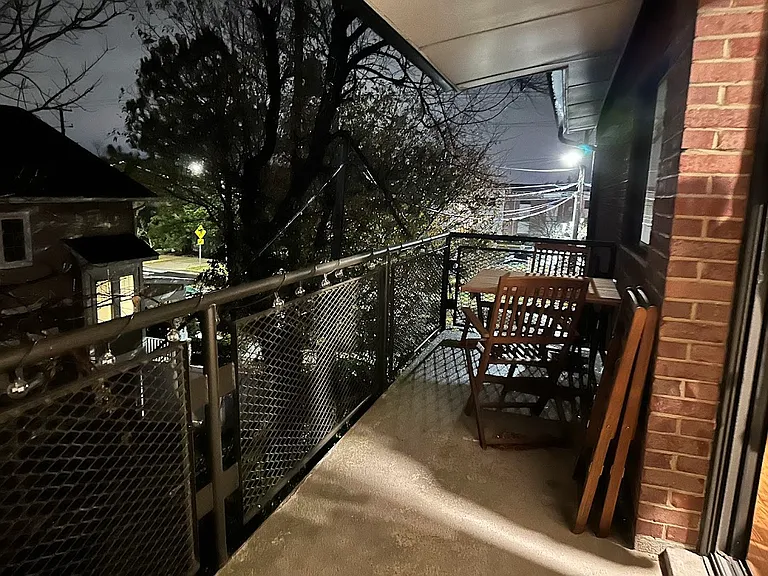 Expansive balcony with a tree-lined view.