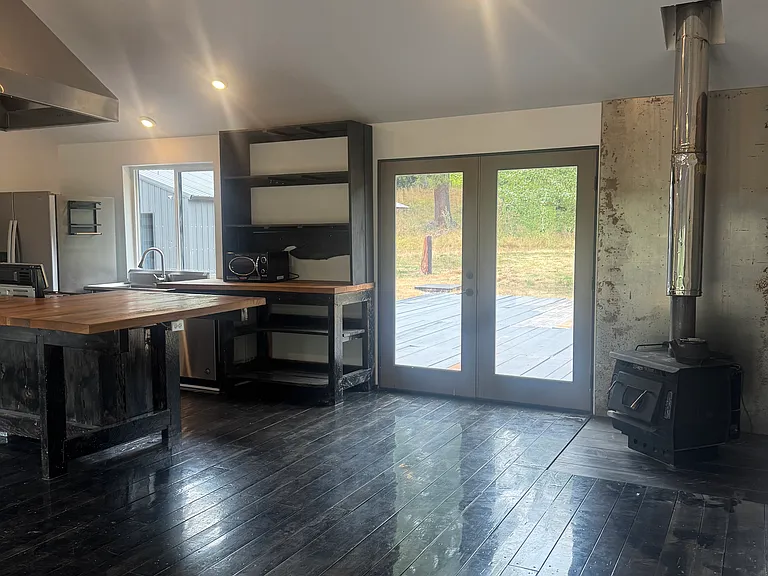 Hardwood Floors, Wood Stove & Patio Door Leading to the Large Backyard Patio
