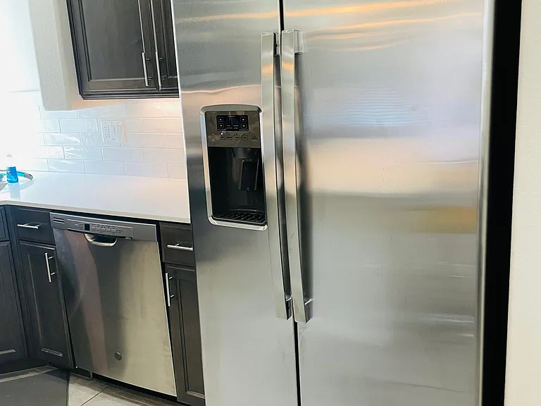 The kitchen has beautiful large stainless steel GE appliances.
