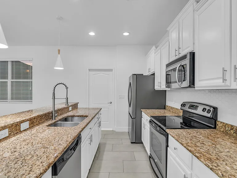 Spacious Kitchen seamlessly opens to Living Room and Dining Room and features granite, stainless steel appliances and large center island with breakfast bar.
