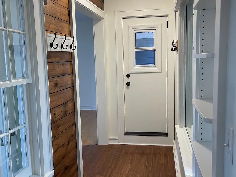Entrance hallway with built-ins, coat hooks, and airing porch.