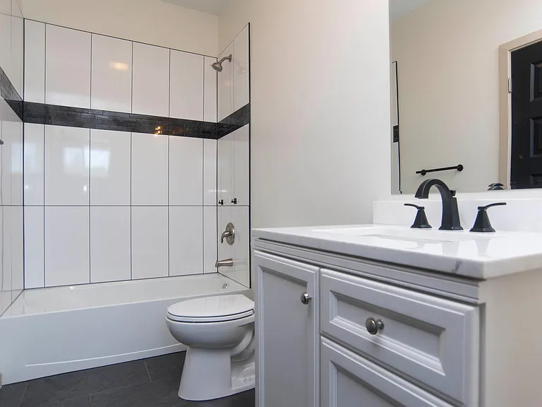 Downstairs bathroom with tub and below sink storage