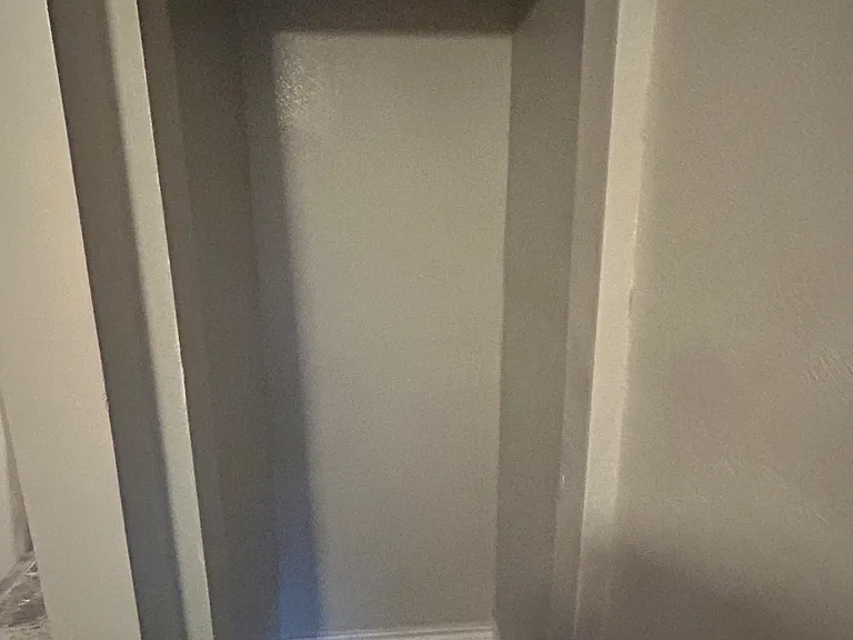 Dedicated closet nook with an upper shelf and hanging rod, offering convenient storage space off the main hallway.