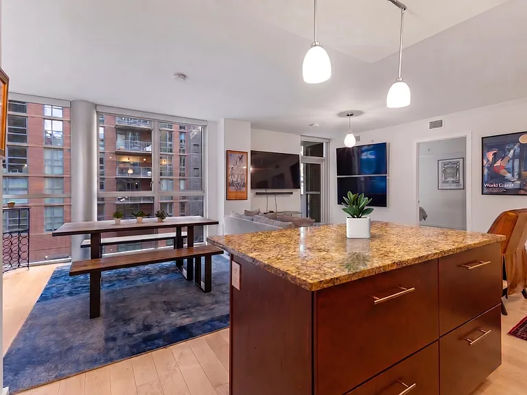 The expansive open-plan layout bridges the kitchen and dining areas, creating a perfect flow for entertaining against a backdrop of city views.