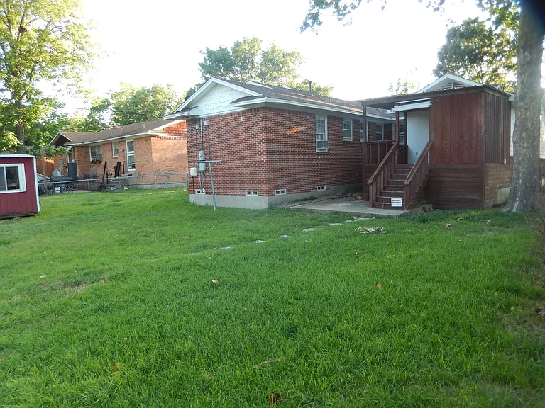 Rear view of the house, yard and storage house on the left