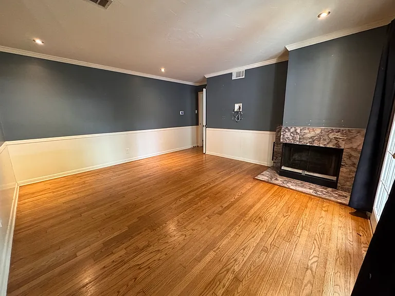 A massive, highly flexible space featuring gorgeous hardwood floors and a striking focal-point fireplace. A brand-new closet is actively being installed, making this room perfect as a spacious third bedroom or an expansive home office.
