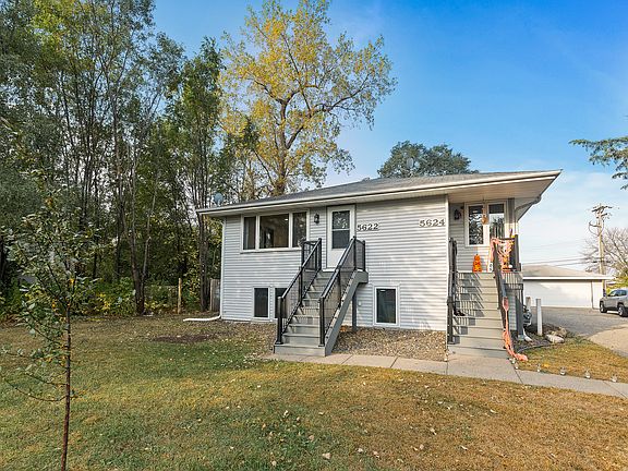 Well-maintained duplex featuring separate entries with maintenance-free stairs, large front windows, and a spacious yard, with lawn care and snow removal included for hassle-free living.