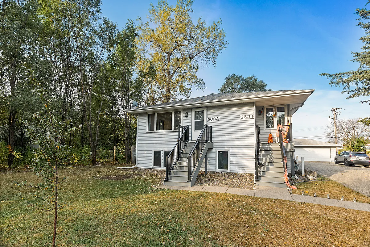 Well-maintained duplex featuring separate entries with maintenance-free stairs, large front windows, and a spacious yard, with lawn care and snow removal included for hassle-free living. - 5622 4th St NE