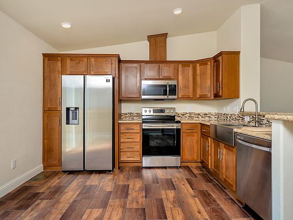Kitchen - Solid wood cabinets, upgraded nickel hardware, title back splashes, highly upgraded stainless appliance package, center island, and country farm sink with pull-out faucet, recessed lighting.