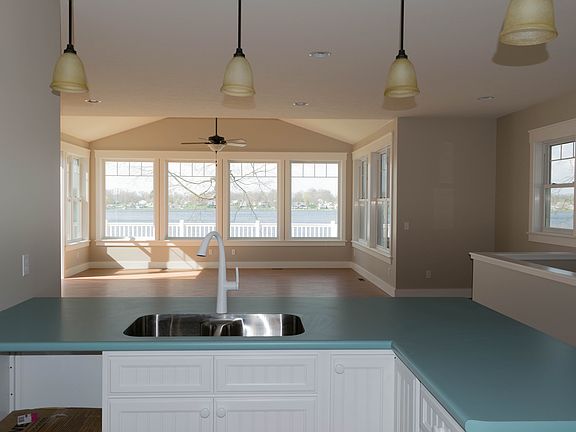 Open floor plan with windows and porch overlooking the lake