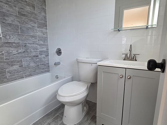 Master Bedroom Bathroom

The master bedroom includes a private full bathroom with a modern design. Features include a tiled bathtub/shower combination, updated vanity with storage, sleek fixtures, and easy-to-clean tile flooring.