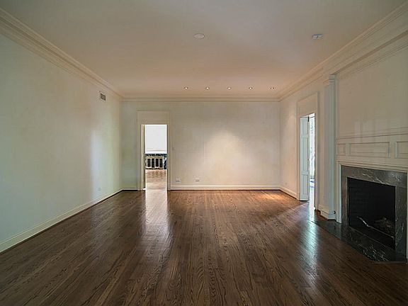 Bi-fold paneled doors that open to the solarium flank the marble fireplace in the large living room.