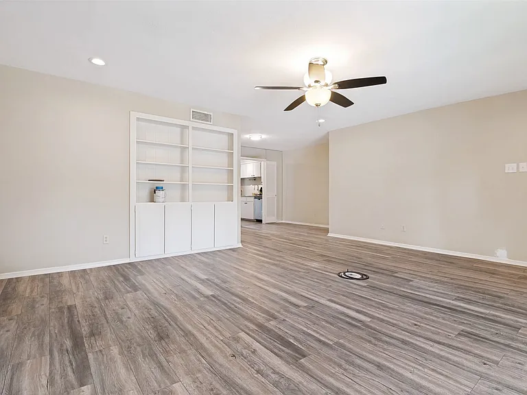 Spacious room featuring wood-finish flooring, recessed lighting, and a ceiling fan