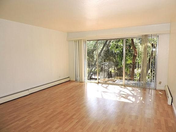 Living room with view of meadow offers lots of light and privacy. The balcony is private to this unit