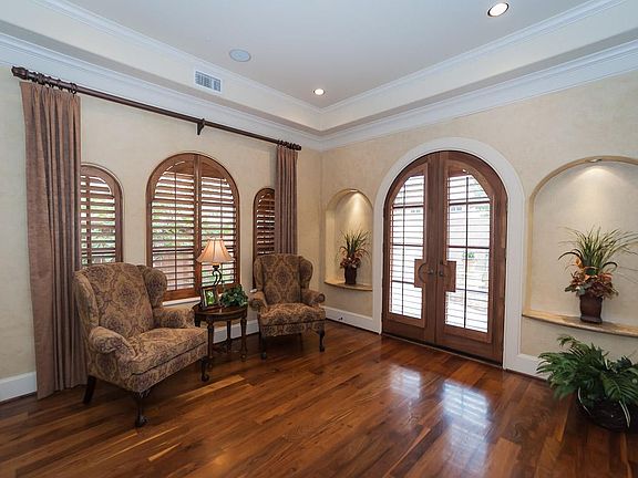 Formal den has walnut flooring, faux painted walls, custom shutters & window treatments. Double doors lead to private patio with fountain.