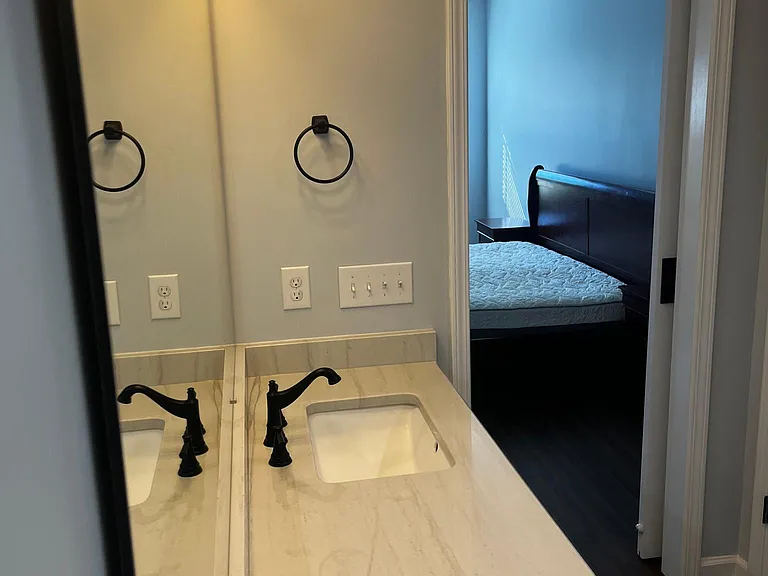 Primary bathroom vanity with dual sinks, generous counter space, and modern black fixtures.