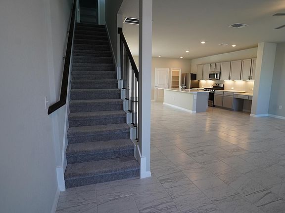 From the front door. Open main floor plan includes kitchen, living area, dining area, walk-in pantry, and half bath.