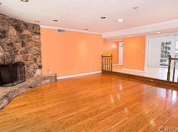 The step down living room with crown moldings and recessed lighting.