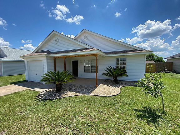 Welcome home! A large front porch and young but fruitful orange tree.