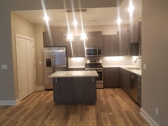 Kitchen with granite countertops and stainless steel appliances. Large pantry area and island seating.