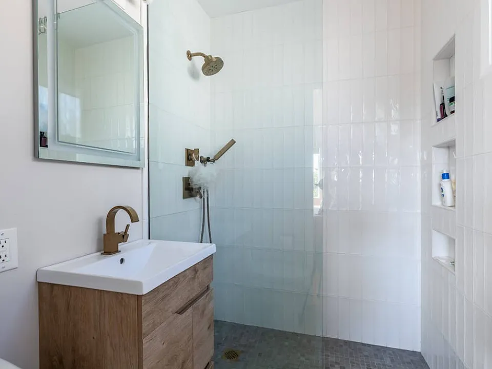 Walk-in shower, LED lit mirror in new bathroom.