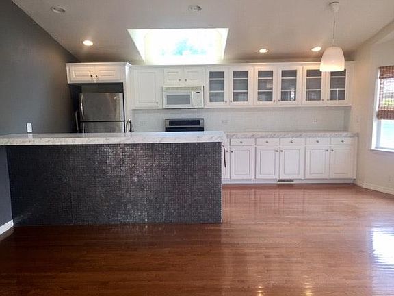 Open plan kitchen, with glass tile backsplash