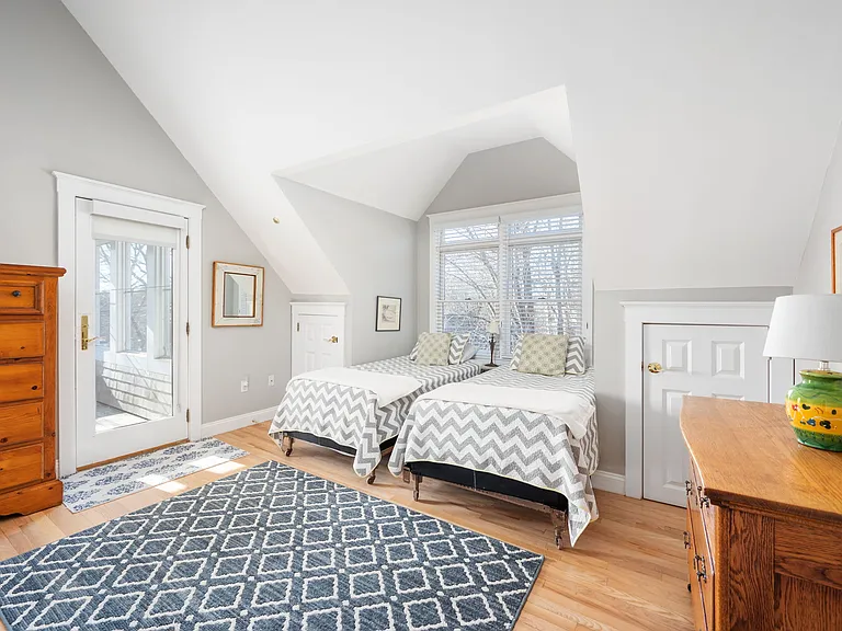 Back right bedroom with twin beds, vaulted ceiling, ceiling fan, large closet, and door to screened in porch.