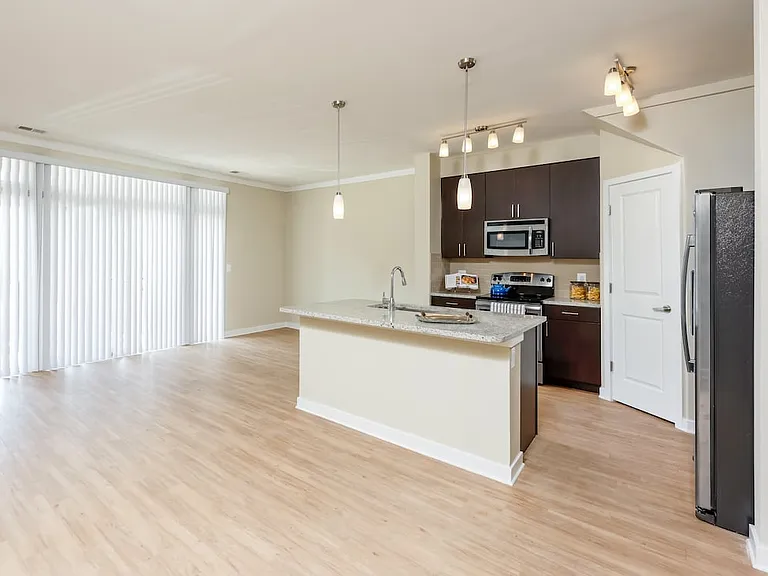 Classic Package II townhome kitchen and living room with hard surface flooring (select homes)