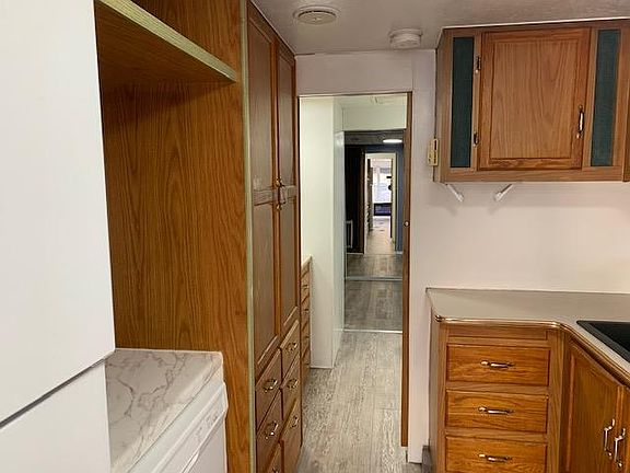 Kitchen area looking back through to bedroom with mirror closet doors.