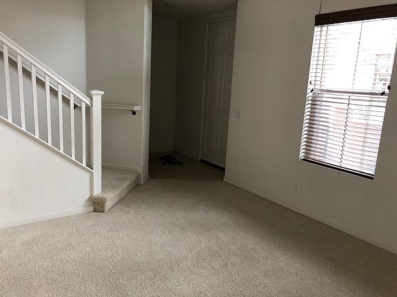 Main door entrance opening to the living room, upstairs going to the dining room/kitchen/family room, and downstairs to attached 2-car garage