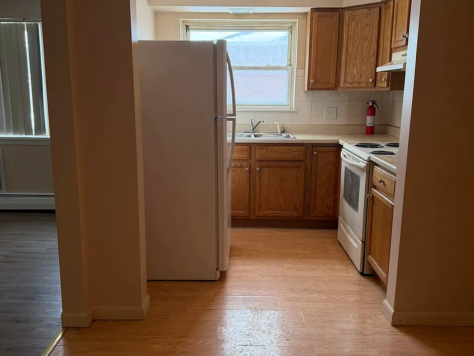 Kitchen includes a fridge and an electric stove.