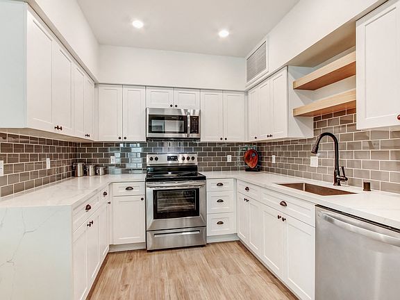 Modern stainless steel appliances with Tile backsplash