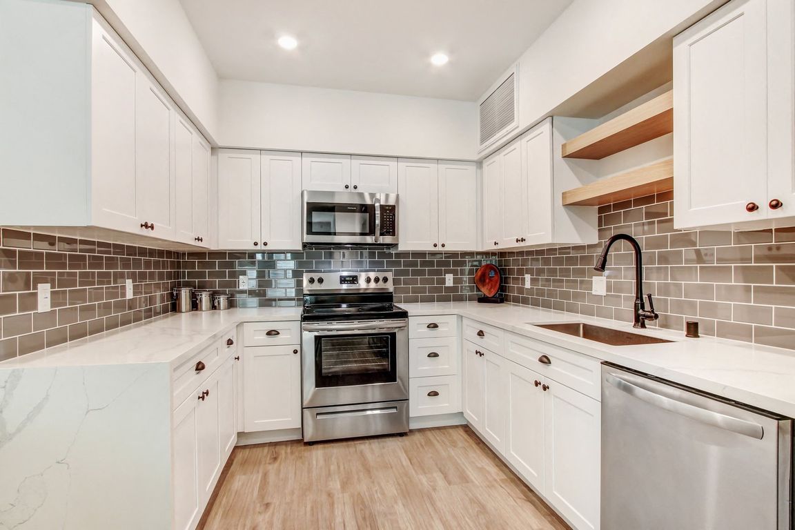 Modern stainless steel appliances with Tile backsplash