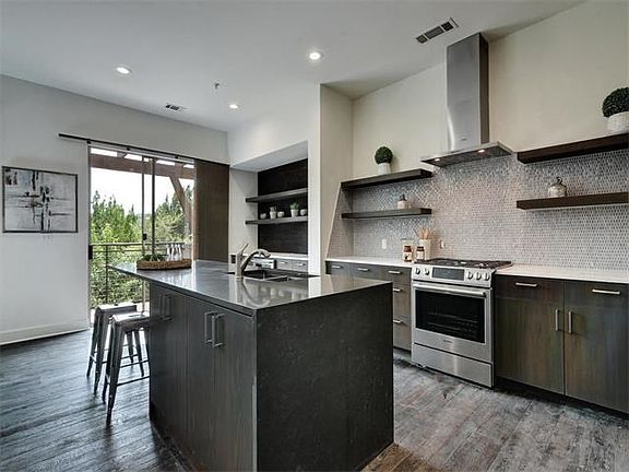 Center island gives way for prep space and an additional place to eat while overlooking the private hill country views! All window coverings freshly installed by Austin Window Fashions, no expense spared!