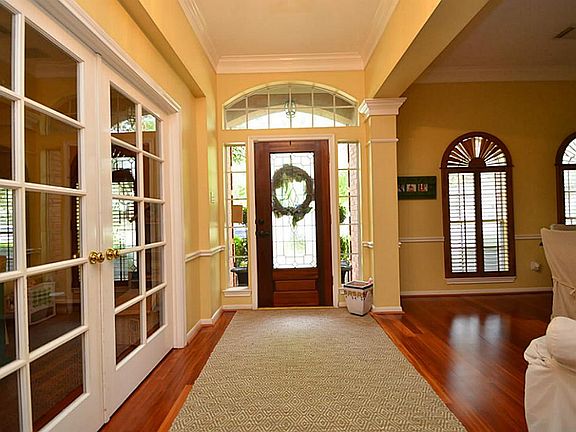 Natural light flows through the door and windows showcasing the beautiful wood flooring.
