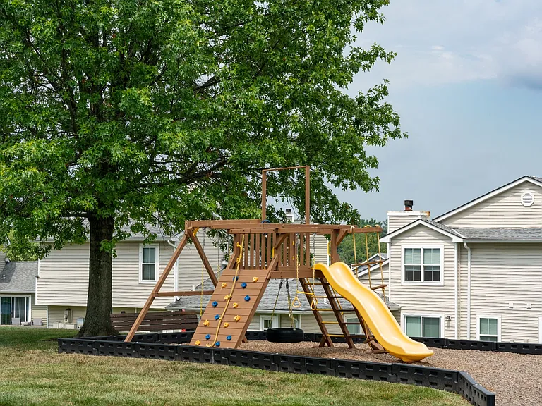 Explore a vibrant playground surrounded by greenery, perfect for kids to play, climb, and enjoy the outdoors.