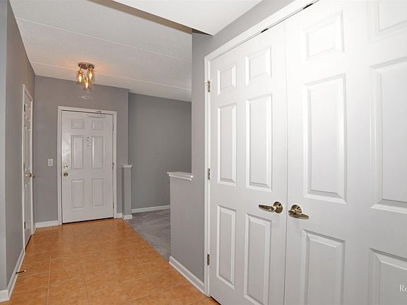 Entrance hallway with view of guest closet, dining and double closets with laundry
