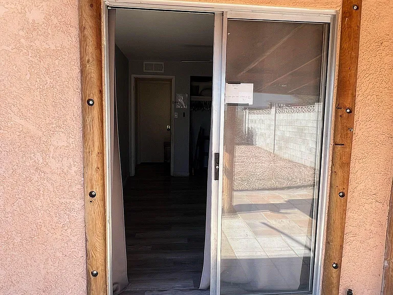 Covered patio entry with a sliding glass door providing direct access between the yard and the home.