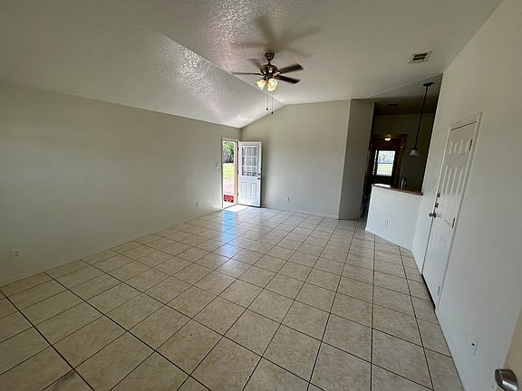 Step inside and be welcomed by a spacious living room that immediately feels open and inviting. The space features bright white tile flooring that not only looks clean and modern but also makes the room feel even larger.

A beautiful arched front window a