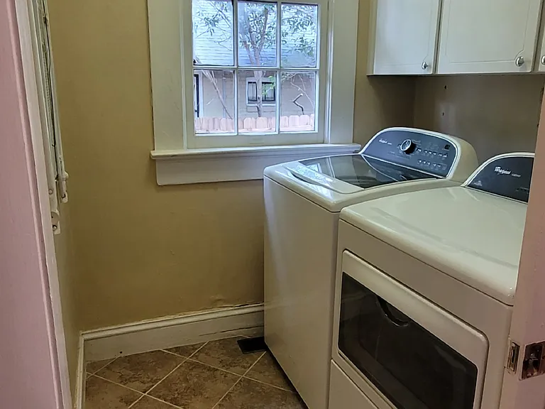 Laundry area with large window creating a bright space, conveniently located off kitchen with a pocket door